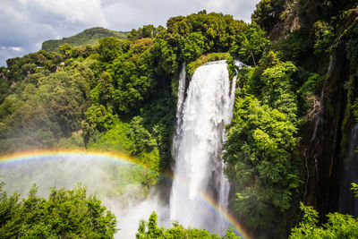 Scenic view of waterfall against sky