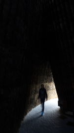 Rear view of silhouette man walking in tunnel