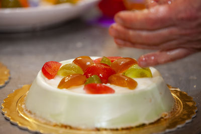 Close-up of hand holding strawberry in plate