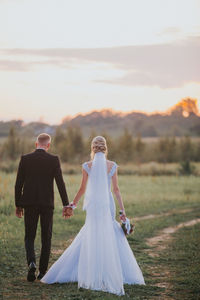 Rear view of couple holding hands