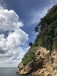 Low angle view of rock formation by sea against sky