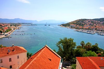 High angle view of houses by sea against sky