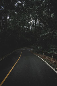 Empty road amidst trees in forest