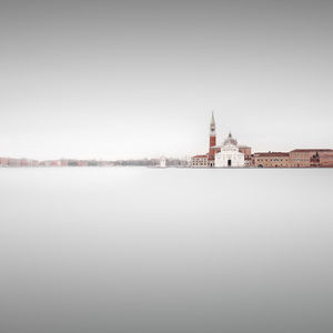 Scenic view of river by building against sky