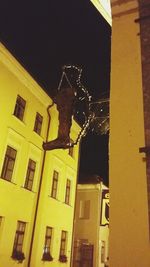 Low angle view of yellow building at night