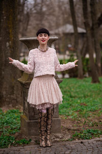 Portrait of woman standing by tree