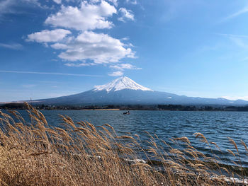 Scenic view of lake and mountains against blue sky