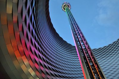 Low angle view of ferris wheel against buildings in city