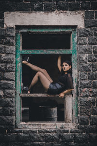 Portrait of woman against brick wall