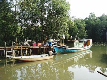 Boat moored in lake against trees