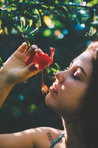 Close-up of woman smelling flower