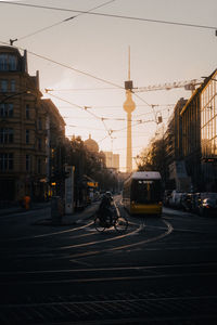 Cars on street by buildings against sky in city