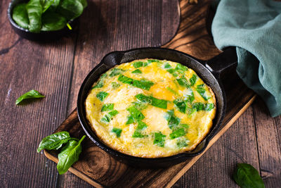 Omelet stuffed with spinach in a pan for breakfast on the table. homemade food.