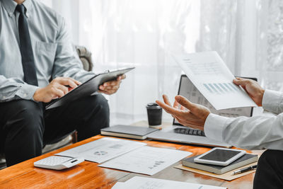 Midsection of man using laptop on table