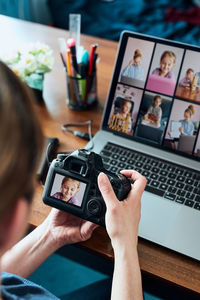 Low section of woman photographing with smart phone on table