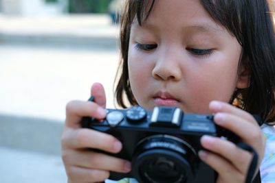 Close-up of cute girl holding camera