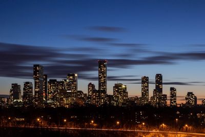 Illuminated buildings against sky at night