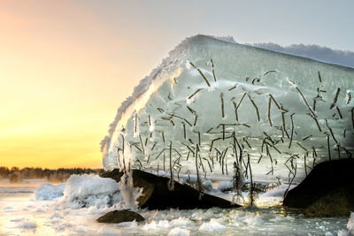 Scenic view of frozen sea against sky during sunset