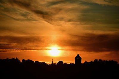 Silhouette buildings against sky during sunset