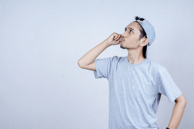 Young man looking away against white background