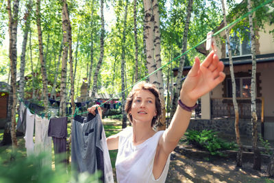 Rear view of woman standing against trees