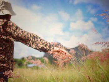 Close-up of woman on field against sky