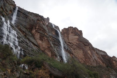 Low angle view of waterfall against sky