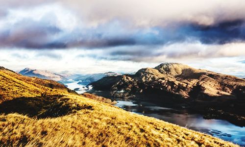 Scenic view of sea and mountains against sky