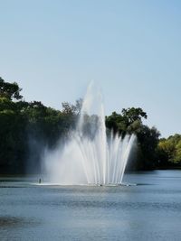 Water splashing in fountain against clear sky