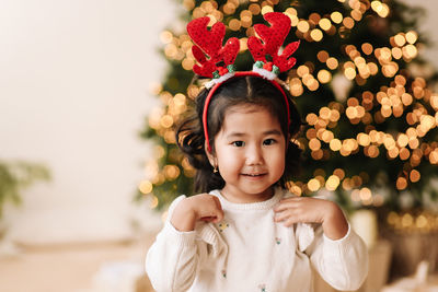 Portrait of an asian emotional  girl child having fun on a christmas holiday in a decorated house