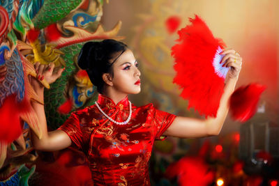 Beautiful young woman with hand fan looking away