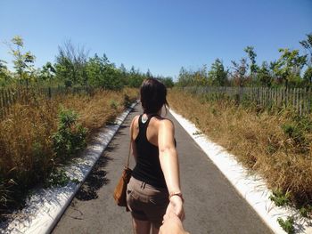 Rear view of woman walking on road