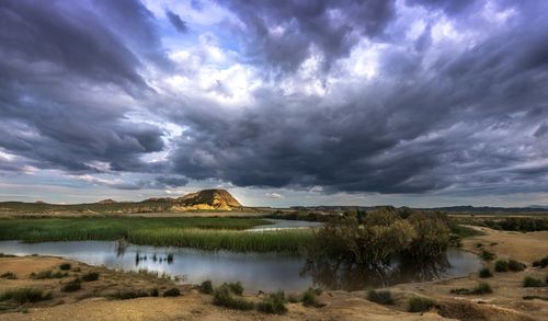 Scenic view of lake by mountains against sky