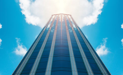 Low angle view of skyscraper against blue sky