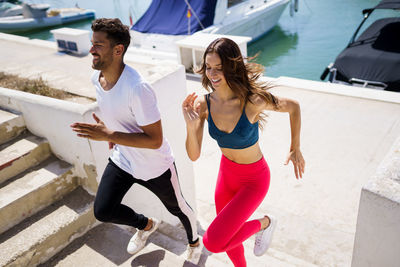 Full length of couple running at harbor