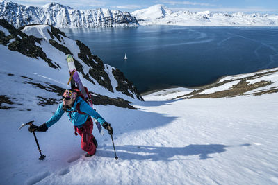 Woman skinning up mountain to ski in svalbard