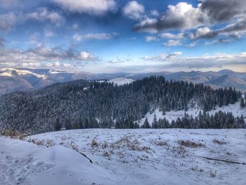 Snow covered landscape against sky