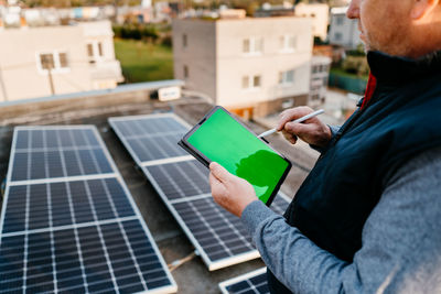 Man using digital tablet on roof