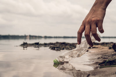 Close-up of hand holding fish at beach