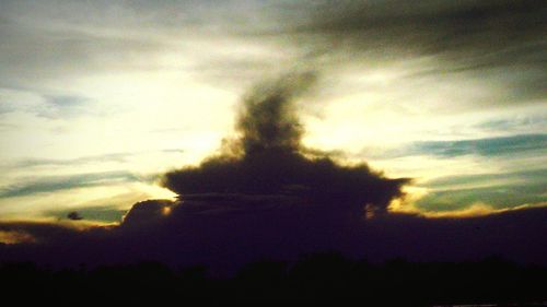 Silhouette of landscape against cloudy sky