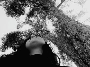 Low section of woman against trees against sky