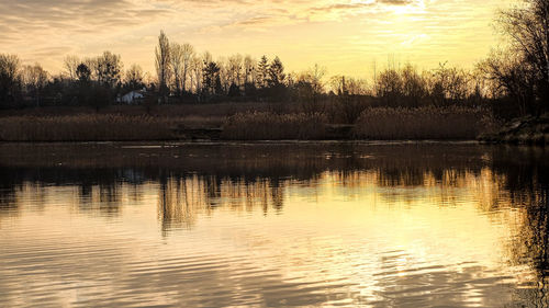 Scenic view of lake against sky at sunset