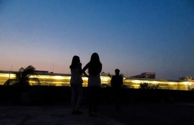 Silhouette of men against sky during sunset