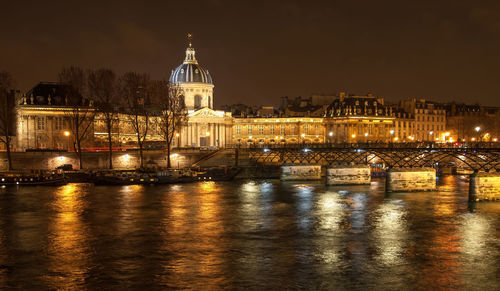 River seine with pont des arts and institut de france panorama at night in paris, france.