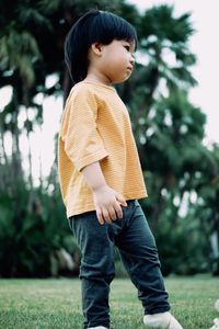 Young woman standing against plants