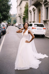 Portrait of smiling young woman standing on street in city