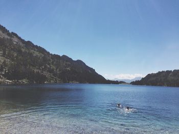 Scenic view of lake against clear blue sky