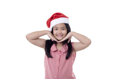 Portrait of smiling girl standing against white background