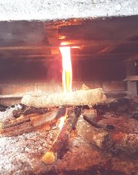 Close-up of burning candle on wood