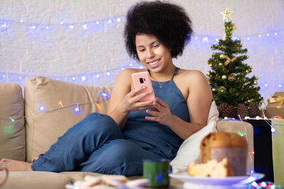 Smiling young woman using mobile phone